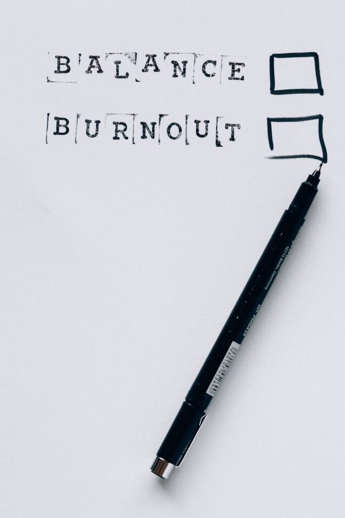 A hand-drawn checklist showing 'Balance' and 'Burnout' with empty boxes, a marker nearby.