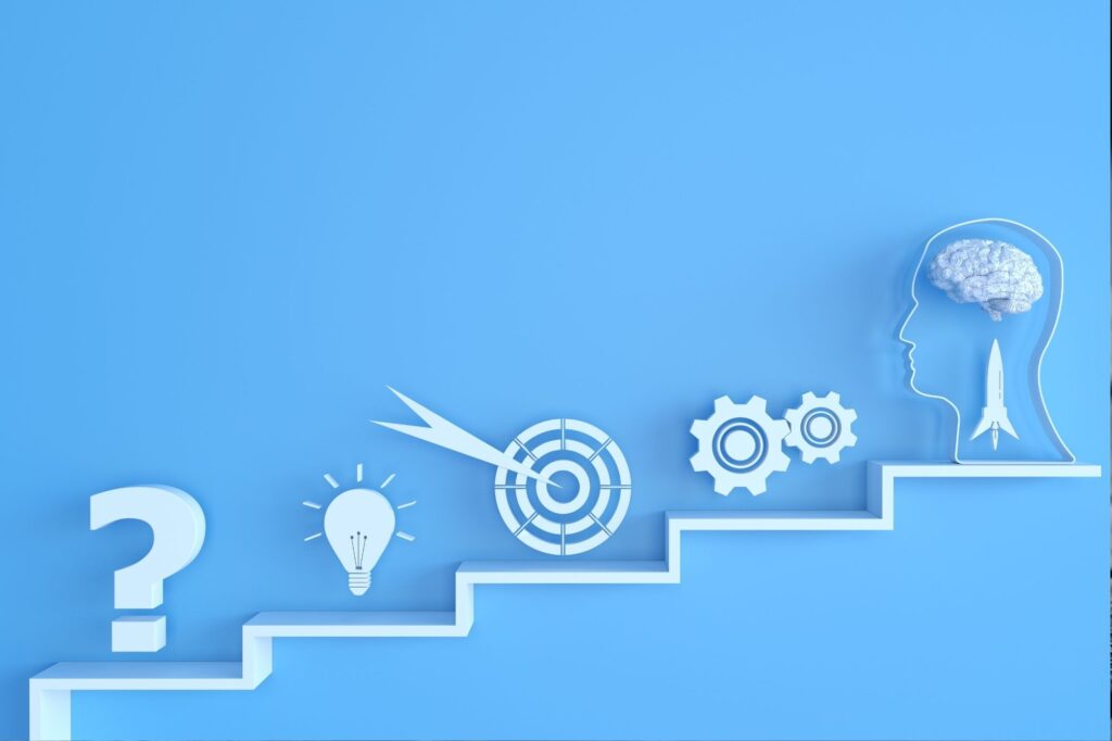 Abstract blue illustration showing a white outline of a head with a brain, rocket, gears, a target, light bulb, and a zigzag staircase—symbolizing ideas and growth.