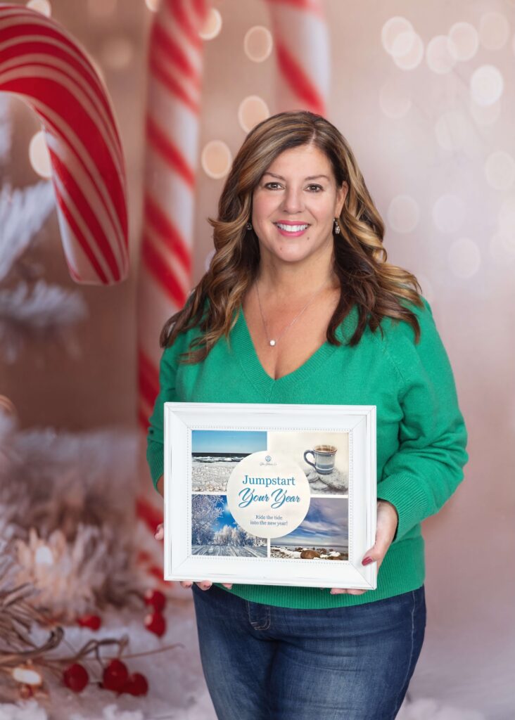 Smiling woman in a green sweater holds a framed photo collage with a holiday theme, standing in front of candy cane decorations.